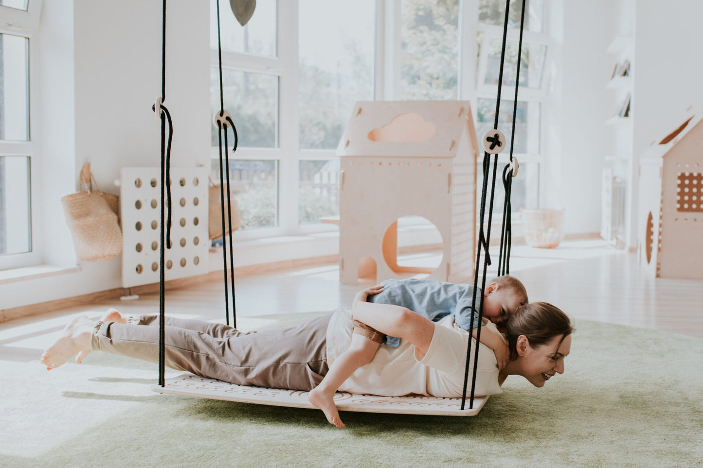 a parent and a child swinging on SENSORY PLATFORM- GOOD WOOD 